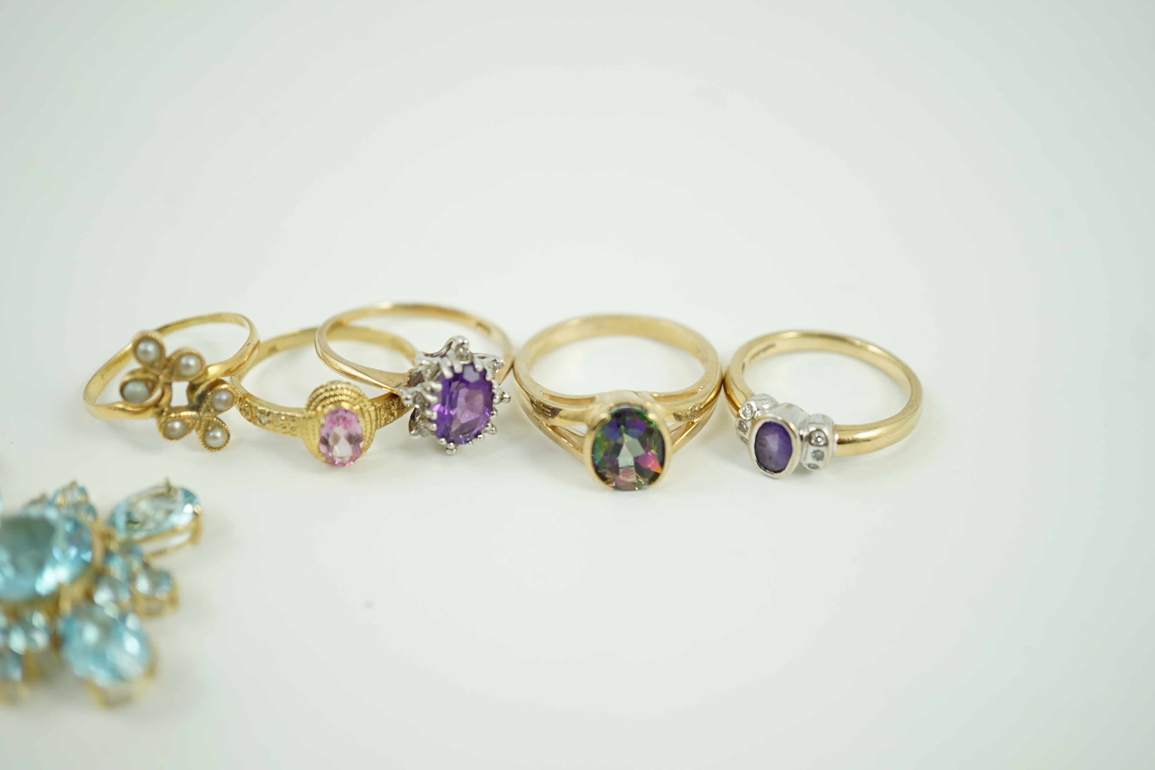 Four assorted modern 9ct gold and gem set rings, a white metal and seed pearl ring and a 9ct gold and blue stone cluster set pendant, 33mm, gross weight 17.9 grams.